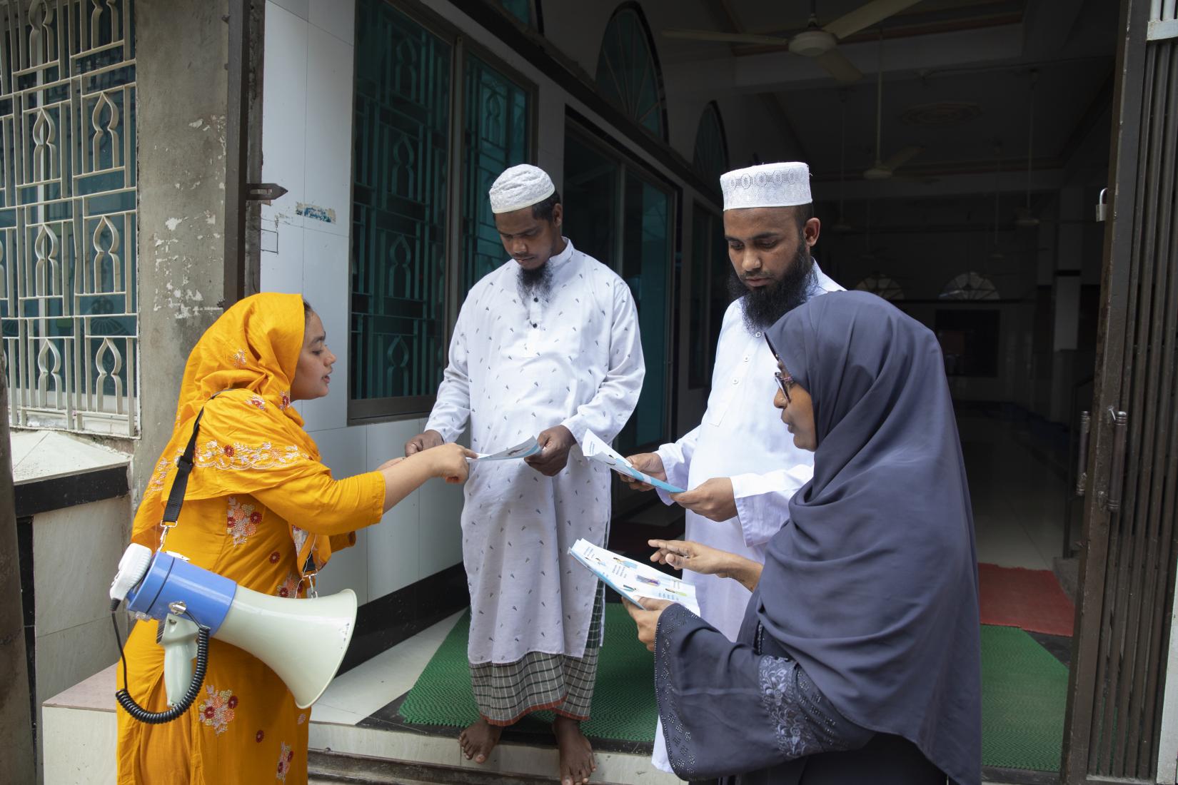 Tahmina Begum, a Community Volunteer, speaks to Imams at the mosque, along with community members, about dengue prevention in Dhalpur, Dhaka